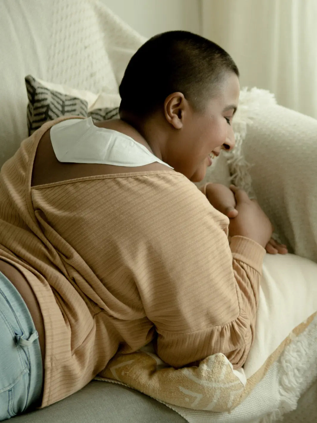 female using backheat while lying on sofa smiling